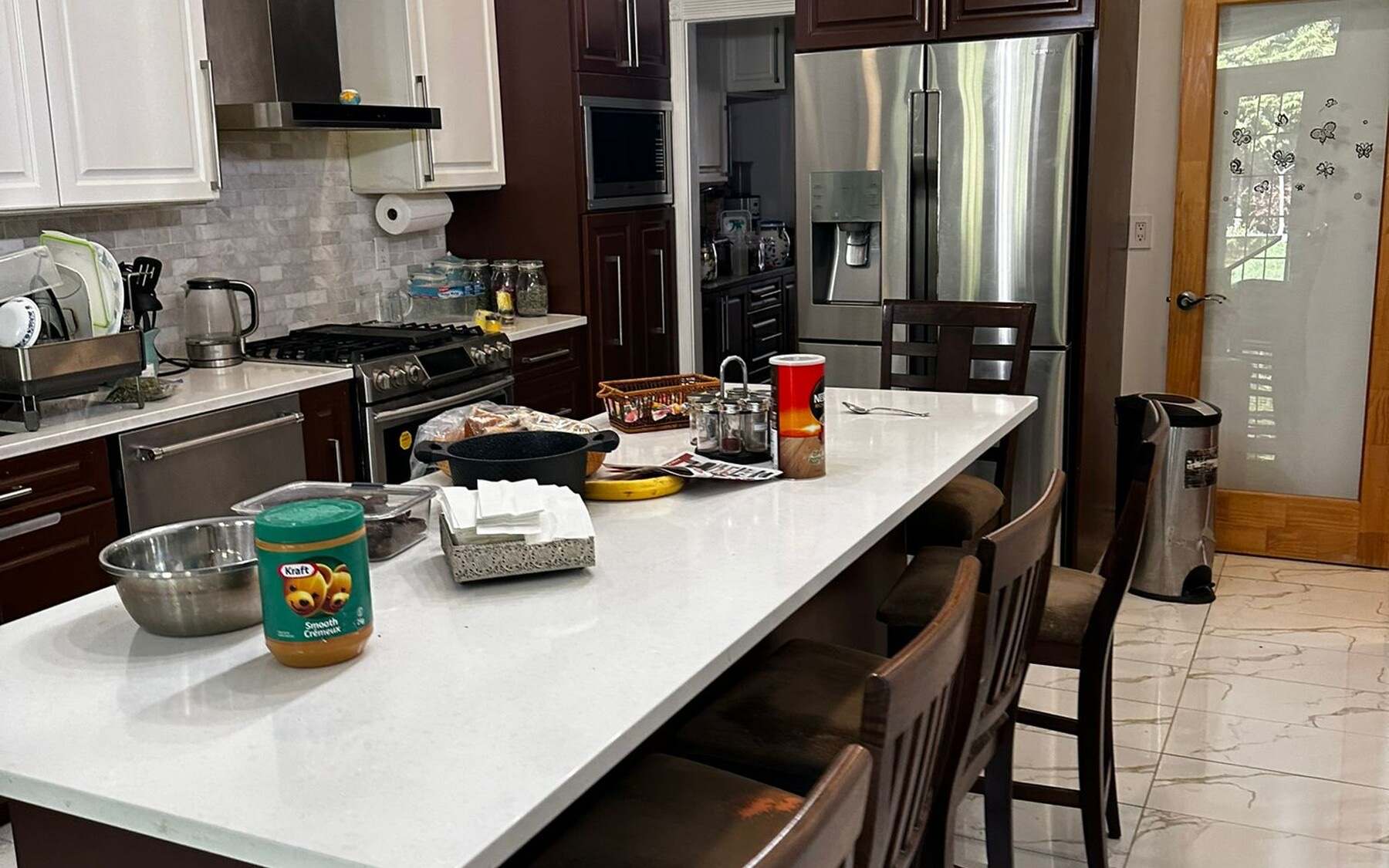 The original Capilano kitchen before renovation: dark cherry cabinetry along a narrow galley with a long white island