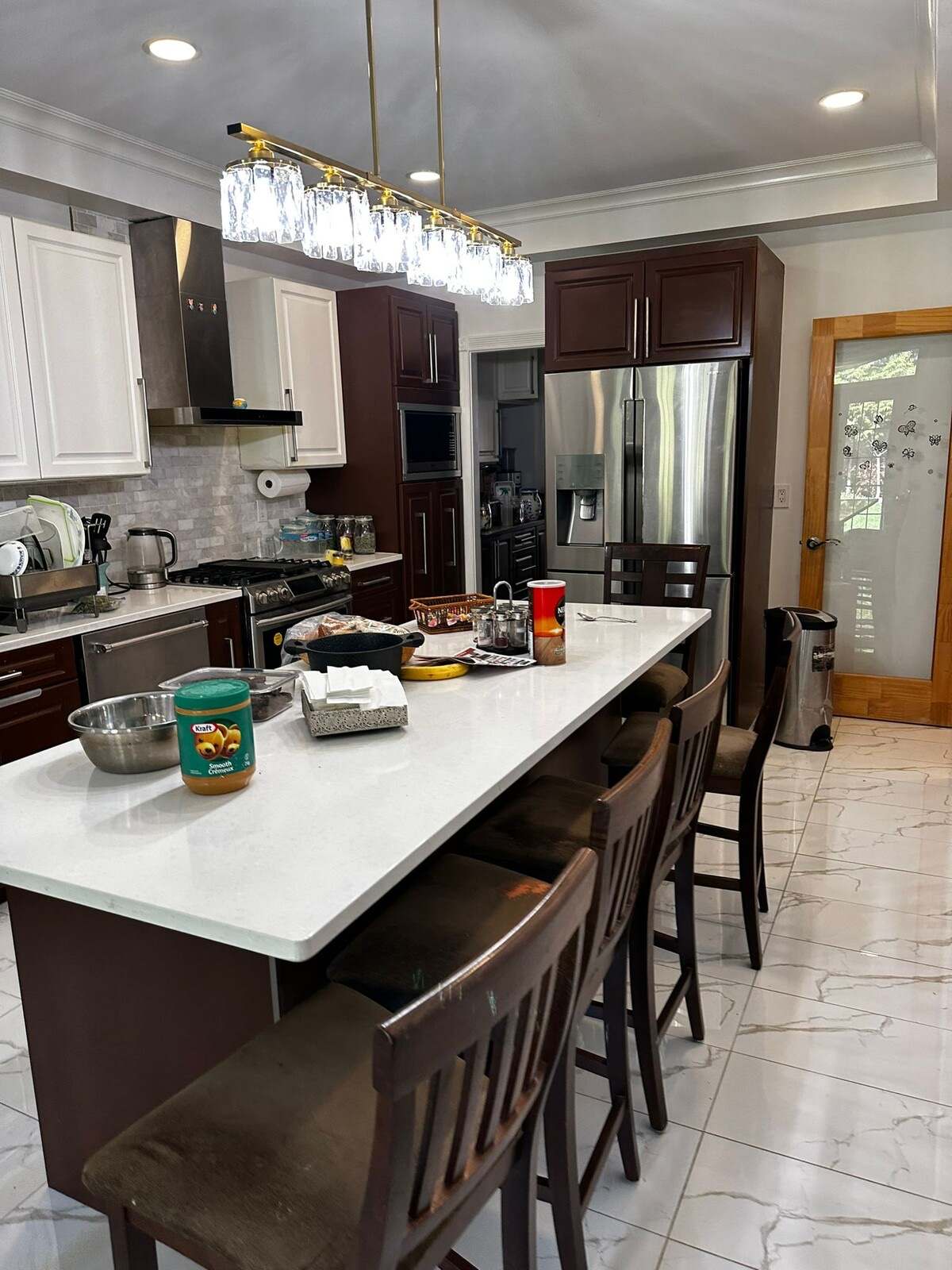 The original kitchen island and bar seating before renovation, looking toward the dark upper cabinets