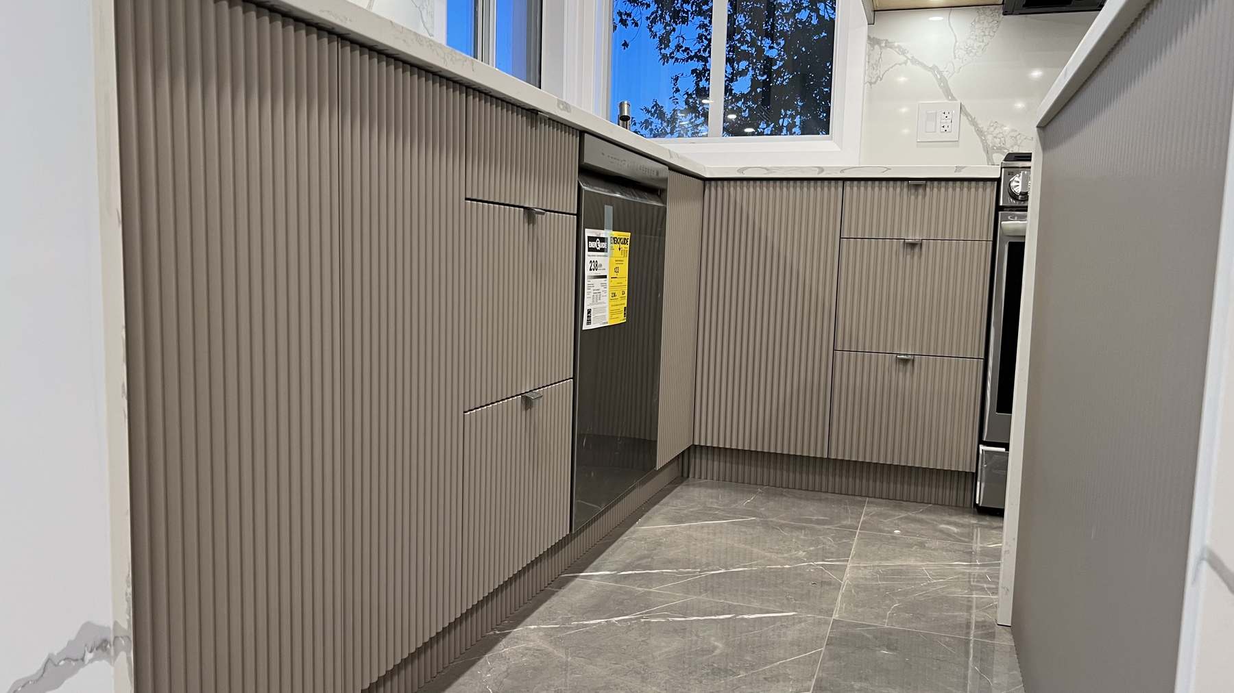 Close detail of the fluted cabinet fronts running the length of the tall pantry and appliance bank